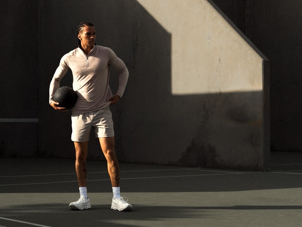A Haus athlete in performance apparel on a sunlit court